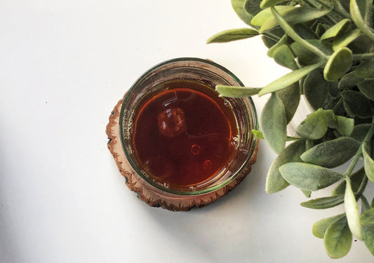 an picture of a black Japanese iced coffee next to a plant 